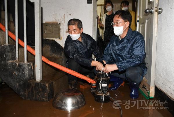 [크기변환]43.이민근 안산시장, 반월동 호우 피해지역 현장 점검…피해 복구에 만전 지시(이민근 안산시장(우측)이 9일 반월동장과 함께 침수 주택을 찾아 배수펌프를 작동하고 있다.).jpeg
