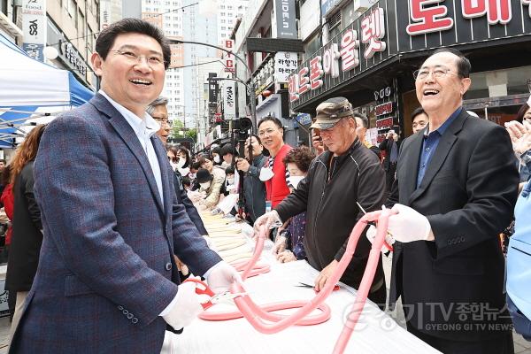 [크기변환]사본 -1-4. 이상일 용인특례시장이 22일 용인중앙시장 봄맞이 축제에서 시민들과 함께 희망 500m 무지개 가래떡 뽑기’ 이벤트에 참여하고 있는 모습..jpg