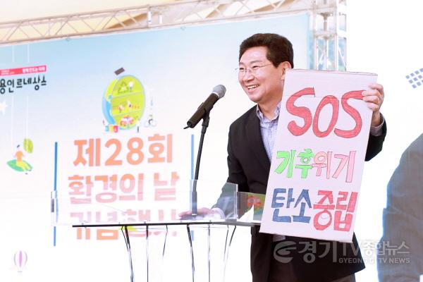 [크기변환]사본 -10-2. 이상일 용인특례시장이 2일 동백호수공원에서 열린 제28회 환경의 날 기념행사에서 인사말을 하며 환경보전 관련 피켓을 들어보이고 있다..jpg