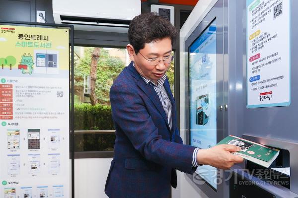 [크기변환]3-2. 이상일 용인특례시장이 지난 11일 기흥구 상갈동 행정복지센터 1층 야외 부스에서 열린 스마트도서관 11호점 개관식에서 도서 반납을 해보고 있다..jpg