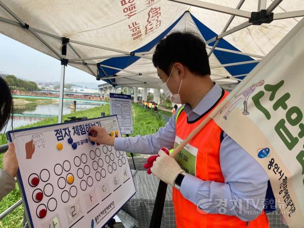 [크기변환]사본 -(사진자료2) 진흥원 직원이 장애인식체험부스에서 점자체험을 하고 있다..jpg