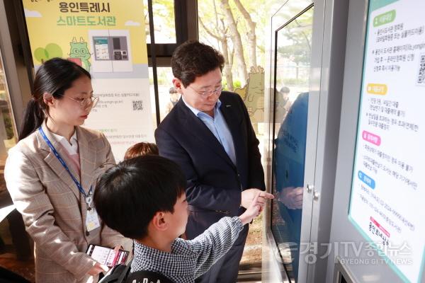 [크기변환]2-3. 이상일 용인특례시장(오른쪽)이 지난 17일 처인구 유림동 유방어린이공원에서 열린 스마트도서관 개관식에서 대출 반납 시연을 하고 있다..jpg
