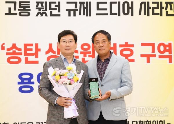 [크기변환]1-3. 이상일 용인특례시장이 24일 처인구 이통장연합회가 남사읍 주민자치센터에서 개최한 송탄 상수원 보호구역 해제 협약 기념 연합회의에서 감사패를 받고 있다..jpg