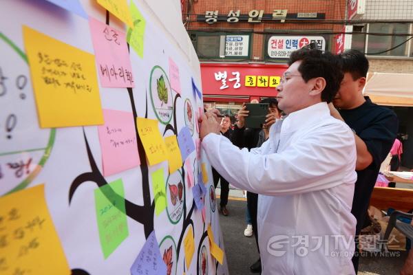 [크기변환]12-2. 이상일 용인특례시장이 27일 신갈오거리 거리축제에서 신갈오거리 도시재생사업의 성공을 기원하는 메세지를 작성하고 있다.JPG