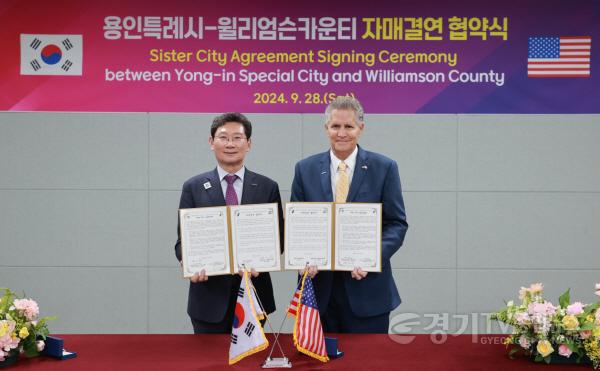 [크기변환]7-2. 이상일 용인특례시장이 지난해 9월 용인시민의 날 행사 현장에서 빌 그래벨 미국 텍사스주 윌리엄슨 카운티장과 자매결연 협약을 맺고 협약서에 서명했다.jpg