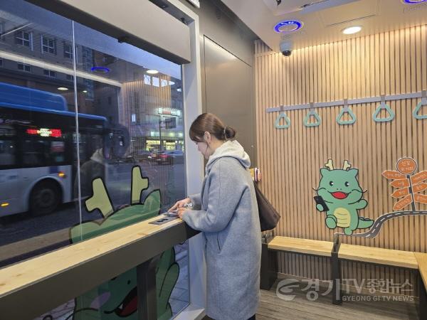 [크기변환]2-2. 한 시민이 스마트 버스 쉼터 안에서 휴대폰을 충전하고 있는 모습..jpeg