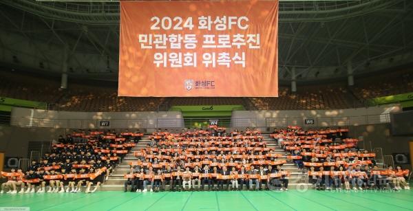 [크기변환]1-2 2024 화성FC 민관합동 프로추진 위원회 위촉식에서 위촉된 위원들이 화성FC 기념수건을 들어올리는 퍼포먼스를 하고 있다.jpg
