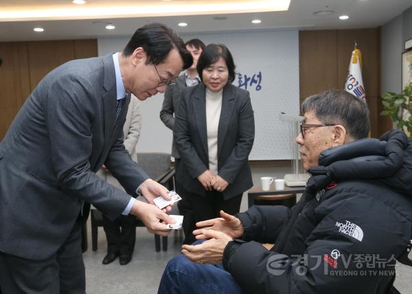 [크기변환]1-8. 정명근 화성특례시장이 경기도시각장애인협회 화성시지회 관계자에게 점자명함을 전달하고 있다..jpg