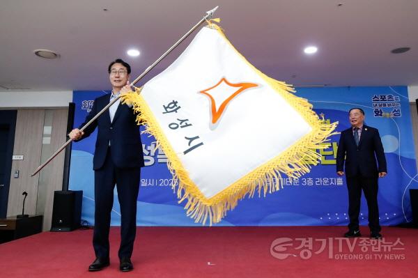 [크기변환]7-2. 정명근 화성특례시장이 경기도체육대회 선수단에 전달하기에 앞서 화성시 깃발을 흔들고 있다..jpg