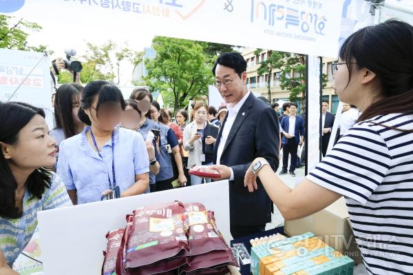 [크기변환]8-2. 정명근 화성특례시장(사진 오른쪽 두번째)이 4일 직거래 장터를 찾은 시민에게 화성특례시 대표 농산물인 수향미를 홍보하고 있다.jpg