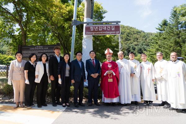 [크기변환](사진3) 용인특례시의회 의원연구단체 용인, 역사종교문화 여행의 시작2 소속 의원들이 11일 청년 김대건 길 명예도로 현판 아래에서 이상일 용인특례시장, 문희종 주교, 수원교구 소속 신부님 등 사제들과 기념 촬영을 하.JPG