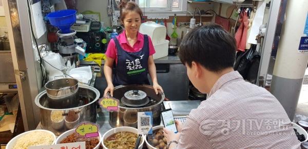 [크기변환]기획보도 사진1_시흥 삼미시장에서 한 시민이 시루로 결제하고 있다.JPG