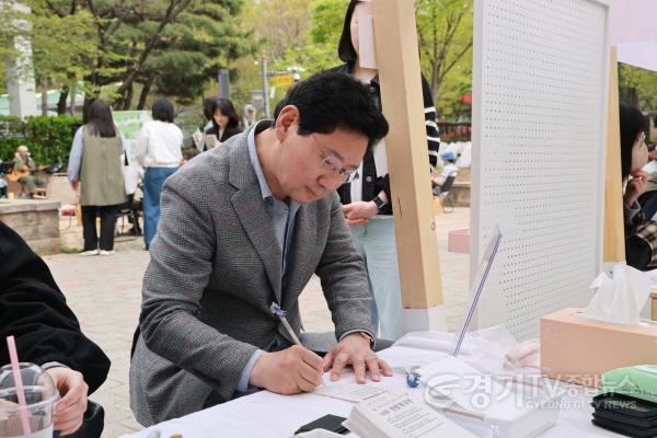 [크기변환]11-4. 이상일 용인특례시장이 17일 수지구 신정공원 독서광장에서 열린 ‘제2회 공원 리딩 파티’ 체험 부스에서 자신의 인생 책을 시민과 공유하고 있다.jpg