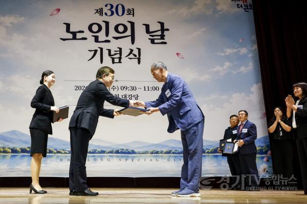 [크기변환]1-1. 조승문 화성특례시 제2부시장(왼쪽)이 30일 화성시청 대강당에서 열린 ‘제30회 노인의 날 기념식’에서 유공자에게 표창을 수여하고 있다.jpg