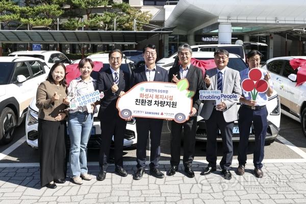 [크기변환]6-2. 정명근 화성특례시장(왼쪽 네 번째)이 6일 복지시설에 기증할 친환경 차량 앞에서 삼성전자 DS부문 및 복지시설 관계자들과 기념촬영을 하고 있다.jpg