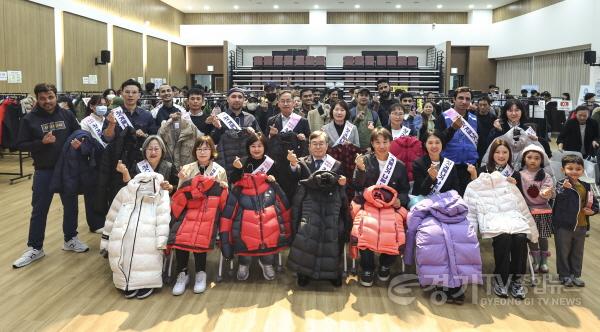 [크기변환]1-2. 이주노동자 첫 겨울나기 나눔 행사에 참석한 주요 내빈과 이주노동자들이 겨울 의류를 들고 기념촬영을 하고 있다.jpg
